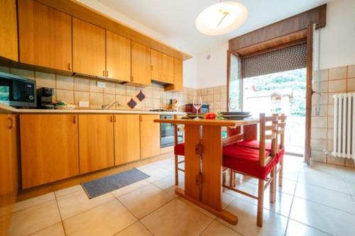 a kitchen with a table and wooden cabinets and a table and chairs at Anna nel verde in Albosaggia