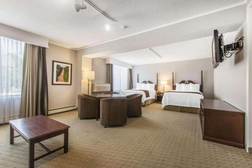 a hotel room with two beds and a table at Quality Inn & Suites Downtown in Charlottetown