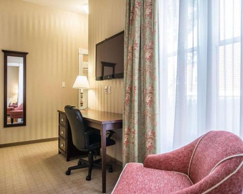a room with a desk and a chair next to a window at Quality Inn & Suites Downtown in Charlottetown