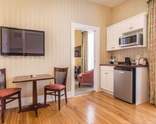 a living room with a kitchen and a table with chairs at Quality Inn & Suites Downtown in Charlottetown