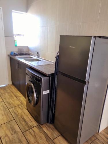 a kitchen with a refrigerator and a washing machine at On-the-Up at Molen in Potchefstroom