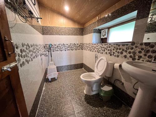a bathroom with a toilet and a sink at Dormigo in Bīr