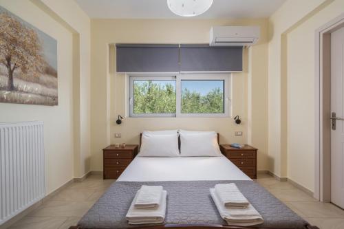 a bedroom with a large bed and two windows at Casa Magnolia in Katokhórion