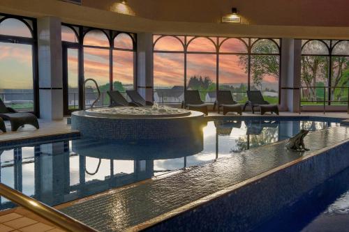 a swimming pool with a fountain in a building at Glasgow Westerwood Hotel, Spa & Golf Resort in Cumbernauld