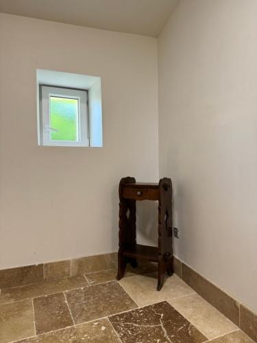 a small window in a white room with a table at Chateau Eck in Cadaujac