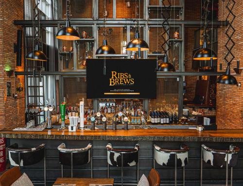 a bar with a sign that reads riss brews at Hilton Dubai Al Habtoor City in Dubai