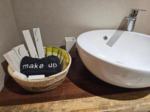 a bathroom with a sink and a basket with the words make up at Dimitra's Paradise Villa in Lygia