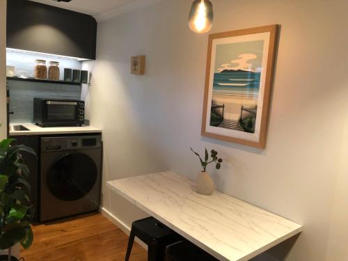 a kitchen with a table and a microwave and a sink at Vista - touch of country and hot Spa in Havelock North