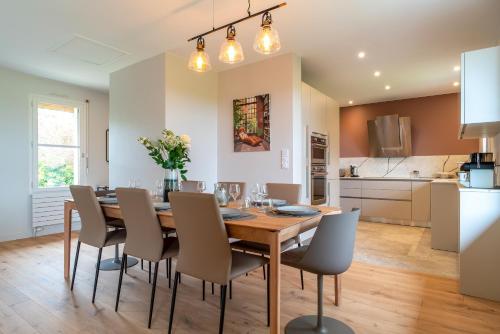 une cuisine et une salle à manger avec une table et des chaises en bois dans l'établissement La Perle du Golfe - A 1km de la plage, à Baden