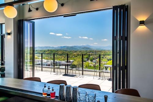 a dining room with a table and a large glass window at Embassy Suites By Hilton Asheville Downtown in Asheville