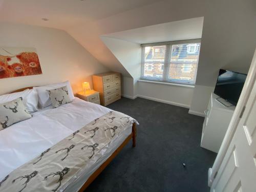 a small bedroom with a bed and a television at Thistle House in Inverness