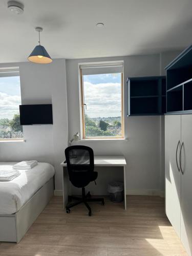 a bedroom with a desk and a bed and a chair at SWUITE GALWAY in Galway