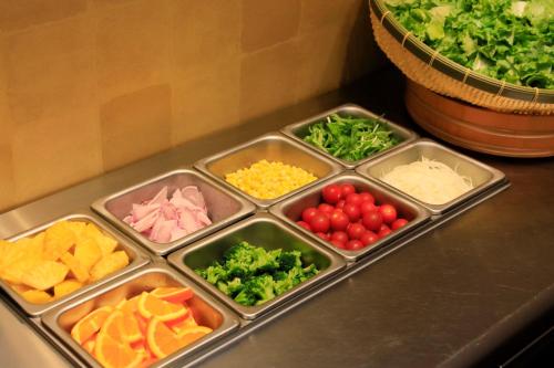 a counter with four trays of different types of vegetables at Richmond Hotel Fukushima Ekimae in Fukushima