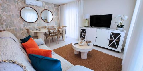 a living room with a couch and a tv at Holidays Nazaré Centro in Nazaré