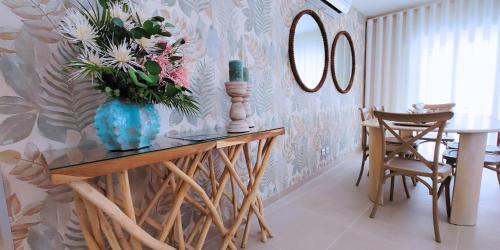 a dining room with a vase of flowers on a table at Holidays Nazaré Centro in Nazaré