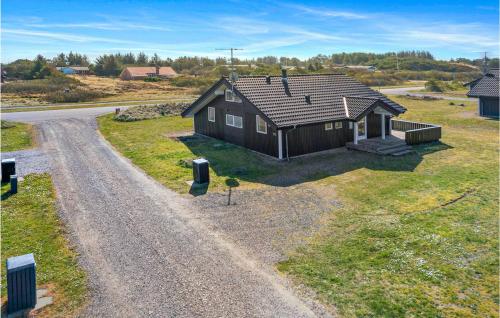 a small house on the side of a dirt road at Søndervig Ferieby in Ringkøbing