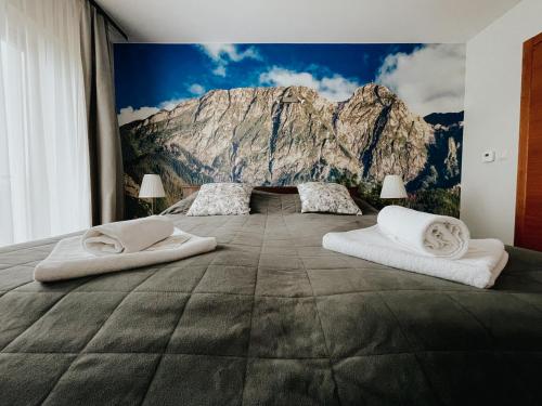 a bedroom with a mountain mural on the wall at Willa Pachówka - tam, gdzie natura spotyka się z nowoczesnością in Bukowina Tatrzańska