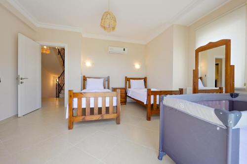 a bedroom with two beds and a mirror at Villa Arokarya in Fethiye