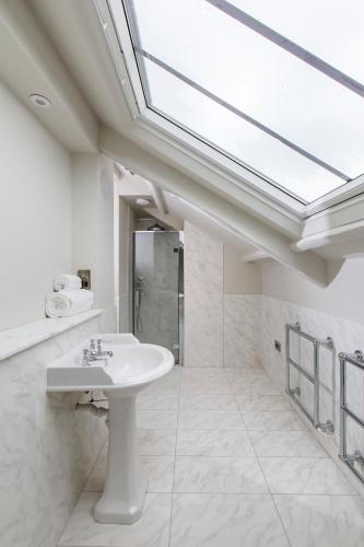 a white bathroom with a sink and a shower at Ffolkes Arms Hotel in Hillington