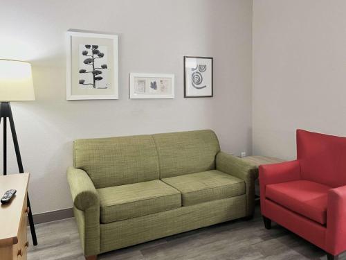 a living room with a couch and a red chair at Country Inn & Suites by Radisson, Tucson Airport, AZ in Tucson