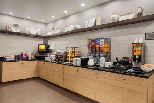 a restaurant kitchen with a counter with dishes on shelves at Country Inn & Suites by Radisson, Gainesville, FL in Gainesville