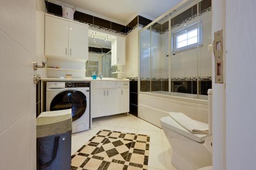a bathroom with a washing machine and a toilet at Villa Arokarya in Fethiye