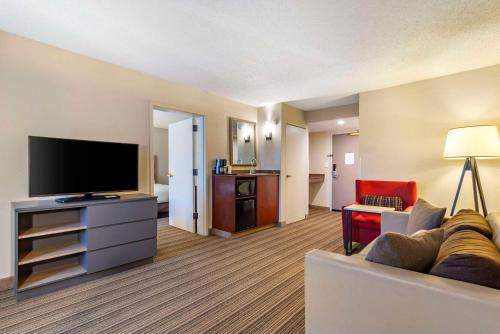 a living room with a couch and a flat screen tv at Country Inn & Suites by Radisson, Atlanta Galleria-Ballpark, GA in Atlanta