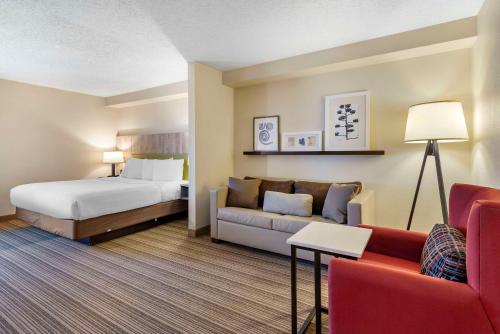 a hotel room with a bed and a couch at Country Inn & Suites by Radisson, Atlanta Galleria-Ballpark, GA in Atlanta