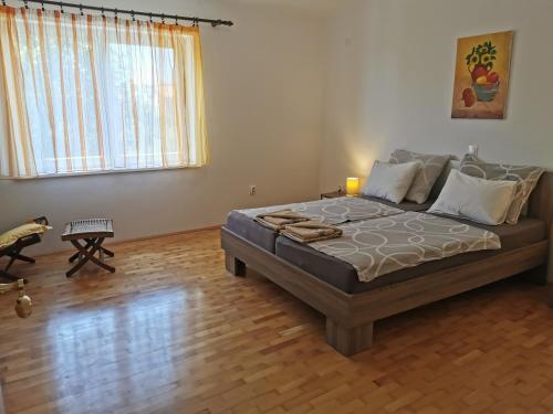 a bedroom with a large bed with a wooden floor at Apartment Kira - spacious apartment with sea view in Ližnjan