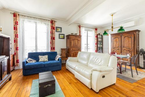 - un salon avec un canapé blanc et une chaise bleue dans l'établissement GuestReady - Vibrant et confortable à Montparnasse, à Paris