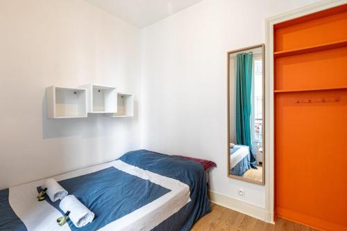 une petite chambre avec un lit et un miroir dans l'établissement GuestReady - Apto Moderno no 19º Arr., à Paris
