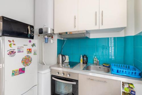 une cuisine avec un évier et un réfrigérateur dans l'établissement GuestReady - Apto Moderno no 19º Arr., à Paris