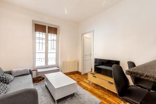 un salon avec un canapé et une télévision dans l'établissement GuestReady - Cozy Apt 10 mins from Arc de Triomphe, à Paris