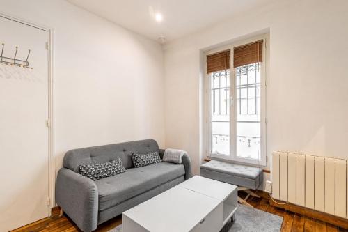 un salon avec un canapé et une fenêtre dans l'établissement GuestReady - Cozy Apt 10 mins from Arc de Triomphe, à Paris
