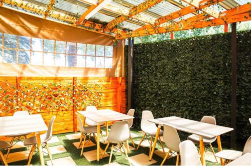 a room with tables and chairs and a green wall at Loft Bella Vita Guesthouse in Bloemfontein