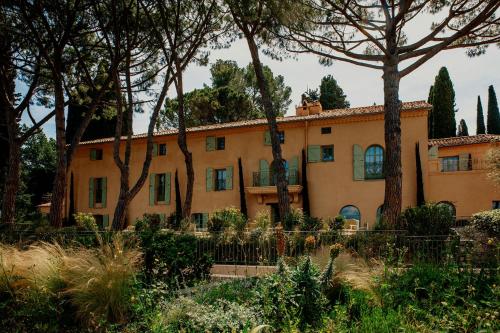 an old house with trees in front of it at Le Mas Candille in Mougins