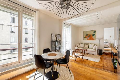 un salon avec une table, des chaises et un canapé dans l'établissement GuestReady - Apt de charme dans le centre de Paris IX, à Paris