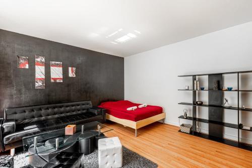 - un salon avec un canapé et un lit rouge dans l'établissement GuestReady - Airy Studio with Courtyard View, à Paris
