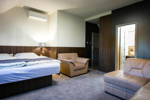 a hotel room with a bed and a chair at New York Pension in Dunajská Streda