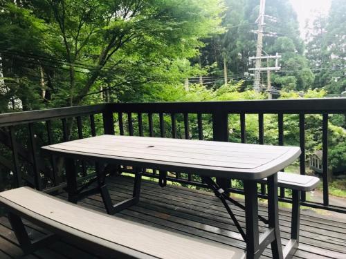 a picnic table sitting on a wooden deck at モリソンヴィラ 石垣のログハウス in Shiso
