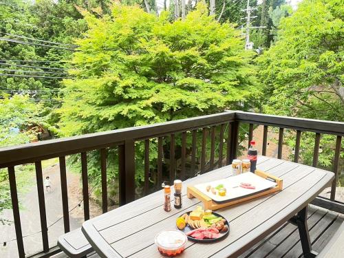 uma mesa de madeira com uma bandeja de comida numa varanda em モリソンヴィラ 石垣のログハウス em Shiso