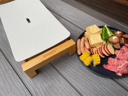 a plate of food with meat and vegetables on a table at モリソンヴィラ 石垣のログハウス in Shiso