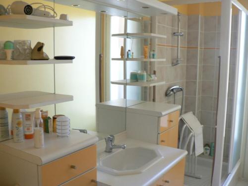 une salle de bain blanche avec un lavabo et une douche dans l'établissement Ensoleillé, à Sanary-sur-Mer