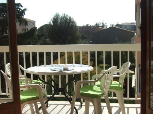un patio avec une table et des chaises sur un balcon dans l'établissement Ensoleillé, à Sanary-sur-Mer