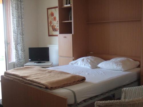 une chambre avec un lit et une télévision dans une pièce dans l'établissement Ensoleillé, à Sanary-sur-Mer