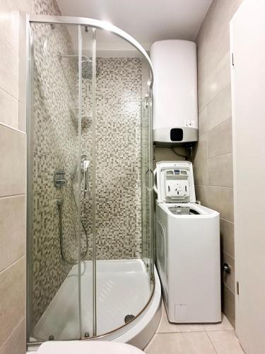 a shower in a bathroom with a washing machine at Mediterranean Apartment 2 in Budva