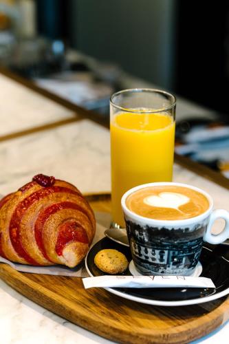 a tray with a cup of coffee and a pastry at Seven Town House Boutique Hotel in Locarno