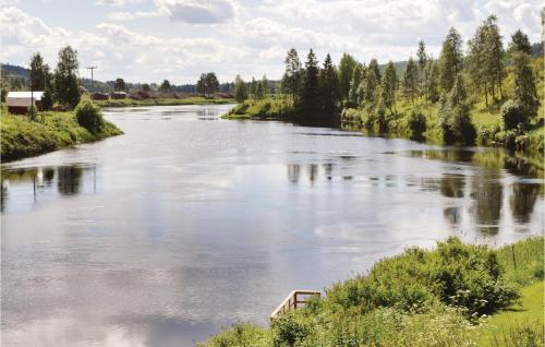 a river with a boat in the middle at Cozy Home In Sälen With Sauna in Stöten