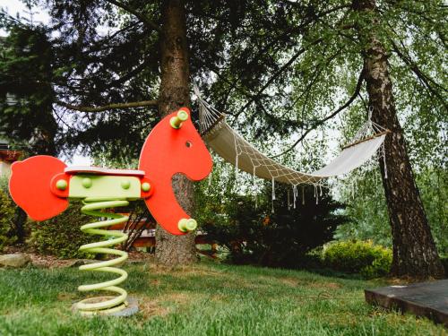 a playground with a toy horse and a hammock at Willa Pachówka - tam, gdzie natura spotyka się z nowoczesnością in Bukowina Tatrzańska