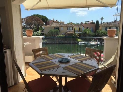 une table et des chaises sur un balcon avec vue dans l'établissement Appartement Port Grimaud, à Grimaud